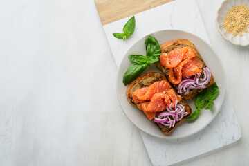 Sandwiches with salted salmon, avocado guacamole, red onions and basil. Smorrebrod. Set of danish open sandwiches. Healthy food, breakfast. Clean eating, dieting, vegan food concept. Top view.