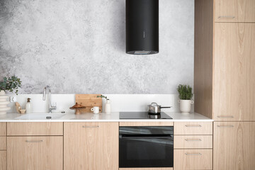 wooden kitchen with built-in electric oven and induction stove