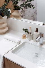 Concept of personal accessories close to wash basin filled water at bathroom