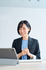 タブレットPCを使って、オンラインコミュニケーションをするビジネスウーマン