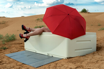 A girl with a red umbrella in an acrylic bath in the desert.