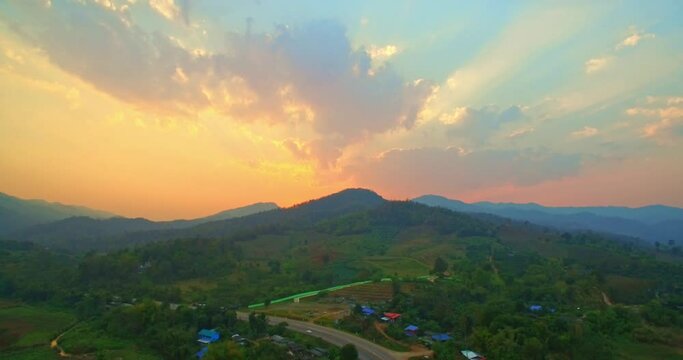 .Beautiful sunset on the hill amid the mountain range with the setting sun in Chiang Rai..Sunbursts flashed in the mountains range in beautiful sunset..Majestic sunset or sunrise landscape.