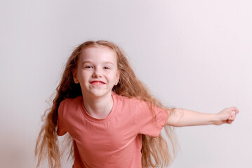 Happy and cheerful girl dancing and rejoicing on a white background