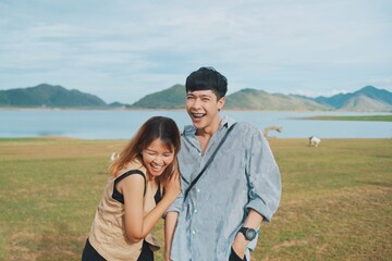 Cheerful Asian couple in the mountains.