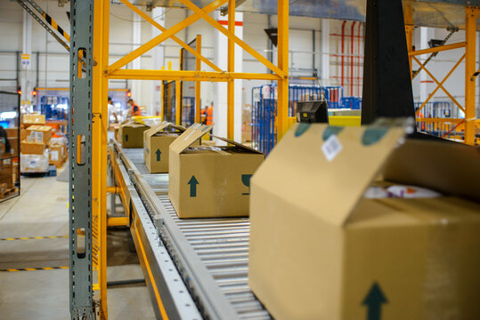 conveyor belt in the delivery warehouse, with packing cartons in the foreground