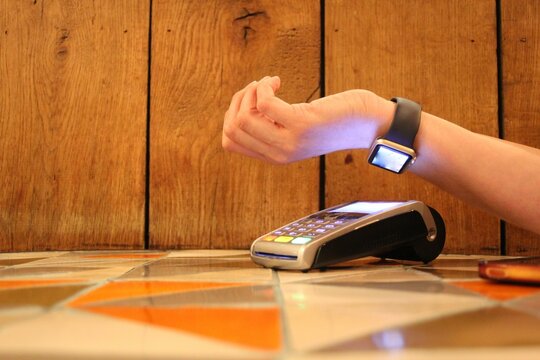 contactless payment smartwatch pdq with hand holding credit card to pay