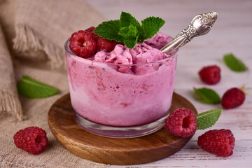 Raspberry ice cream in a glass with fresh raspberries. Close-up.
