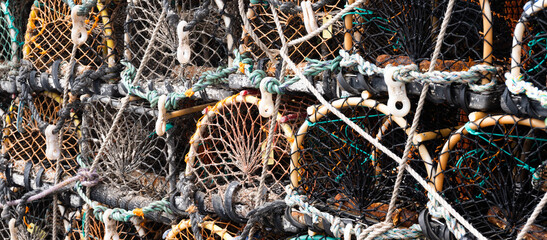 Empty crab pots, stacked on harbor side.