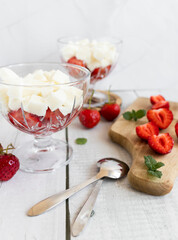 
Strawberry dessert with whipped cream and fresh strawberries. On a white wooden background