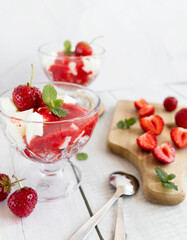 
Strawberry dessert with whipped cream and fresh strawberries. On a white wooden background