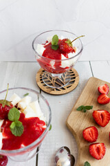 
Strawberry dessert with whipped cream and fresh strawberries. On a white wooden background