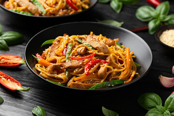 Stir fry chow mein noodles with pork and vegetable in black bowl. asian style food