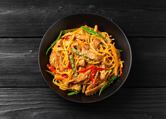 Stir fry chow mein noodles with pork and vegetable in black bowl. asian style food