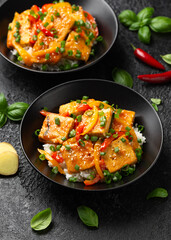 Homemade Stir Fry Tofu with Vegetables and Rice in black bowl.
