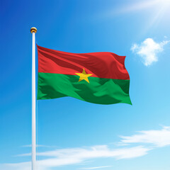 Waving flag of Burkina Faso on flagpole with sky background.