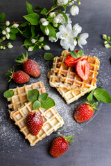 Viennese and Belgian waffles decorated with strawberries, powdered sugar and mint