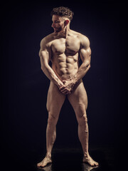 Fototapeta na wymiar Portrait of naked handsome man covering crotch