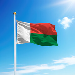 Waving flag of Madagascar on flagpole with sky background.