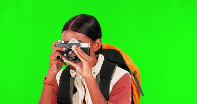 Hiking, camera and photograph with a woman on a green screen background in studio to explore for adventure. Smile, photography or picture with a young female photographer excited against chromakey