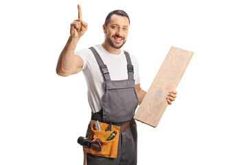 Carpenter holding a wooden floor beam and pointing up