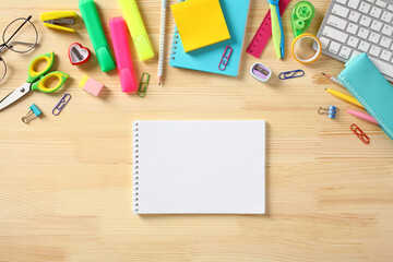 Blank paper notebook with school supplies on wooden background. Back to school concept.