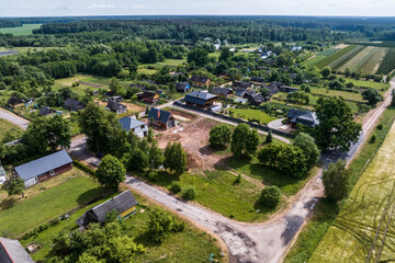 panoramic aerial view of eco village with wooden houses, gravel road, gardens and orchards