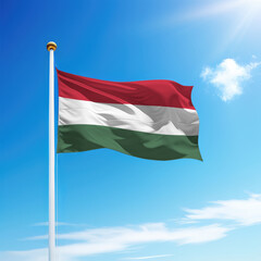 Waving flag of Hungary on flagpole with sky background.