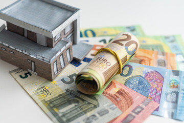 Concept of expenses for new home; small house, dollar paper money.