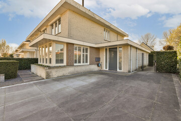 a house in the middle of an urban neighborhood, with no cars or people on the street and one car parked outside