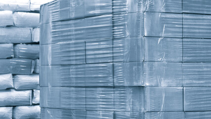 Cardboard boxes on a pallet wrapped in plastic wrap ready for delivery in a warehouse, logistics...
