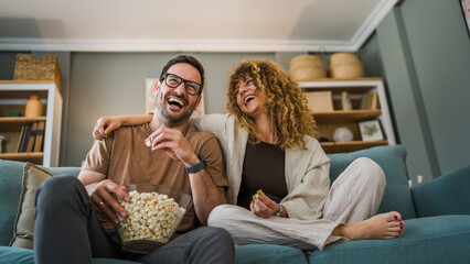 Couple caucasian man and woman sit at home on sofa bed watch tv movie