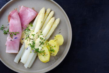 Traditionell gedämpfter weißer Spargel mit Wacholderschinken und Salzkartoffel in Sauce...