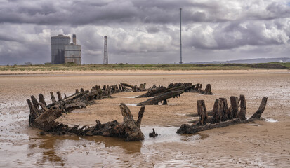 Fototapeta na wymiar Remains of wooden fishing boat embedded in sand on Teeside