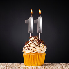 birthday cupcake with number 11 candle - Celebration on dark background