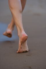 Barefoot woman walking on sandy beach. Space for text.