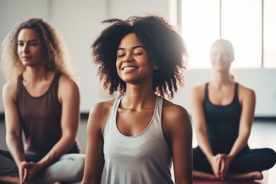 Group of mixed race smiling women practicing yoga in the gym 
