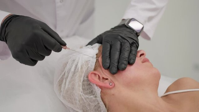 A surgeon performs a face lift