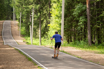 Roller skis.A man runs in a summer park on roller skis.Cross country skilling.