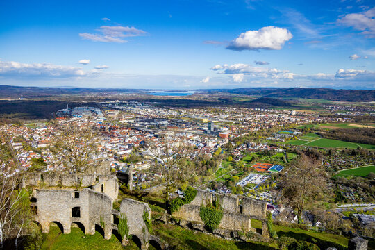 Flight over the castle Hohentwil against the backdrop of the city of Singen, hills and a cloudy sky