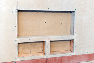 Three alcoves and shelves for shampoo and soap being built during construction and remodel of a...
