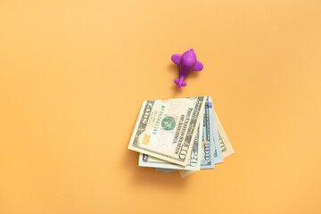 Toy air plane with cash money top view, flat lay on orange background.