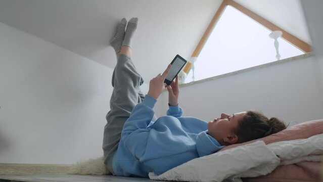 Woman reads e-book in her cozy apartment, 4k