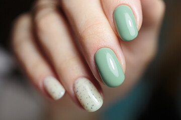 Female hands with nail design close-up. Beautiful female nails with green manicure.