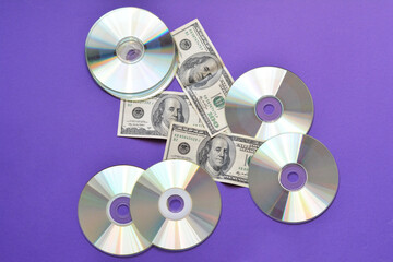 CD-ROM on purple background with dollars