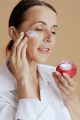 smiling modern female in white shirt isolated on beige