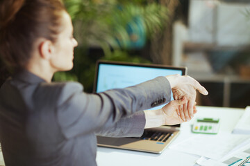 business owner woman in green office stretching hand