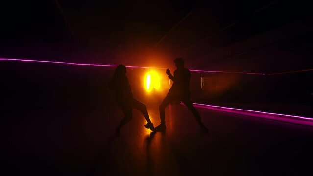 Dancing modern couple silhouette. Freestyle hip hop dancers.