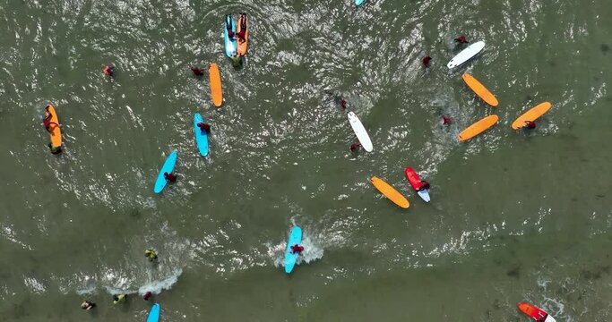 Top view of the beach with surfers practising their wave 4k