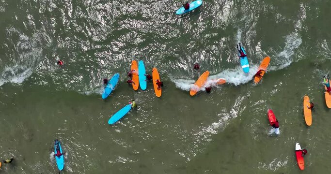 Top view of the beach with surfers practising their wave 4k