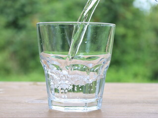 close-up of a glass beaker being filled with water